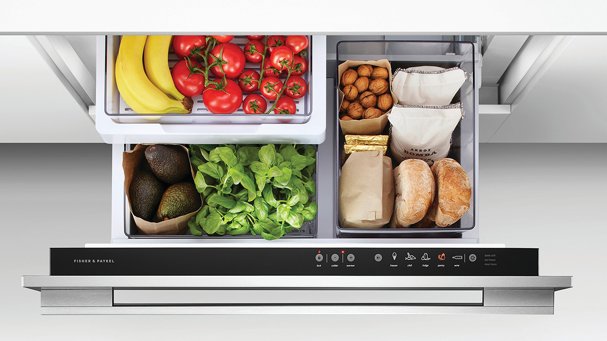 Open refrigeration drawer with fresh fruit, vegetables and bread.