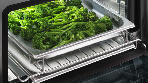 Open Single Shelved Oven with a Tray of Steamed Broccoli.